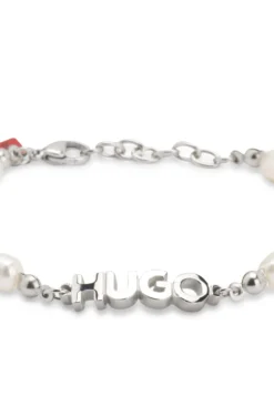 Pearl cuff with metal logo plaque