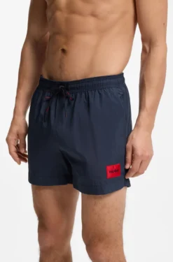 Quick-drying swim shorts with red logo label