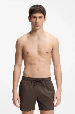 Quick-drying swim shorts with red logo label
